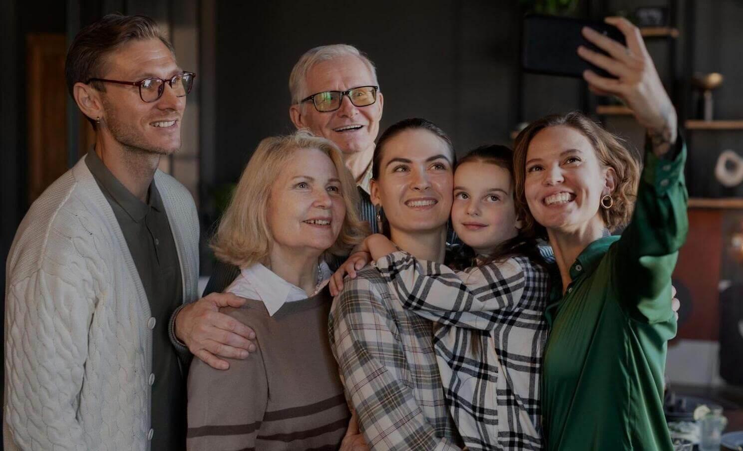Plusieurs personnes de différentes générations prennent un selfie