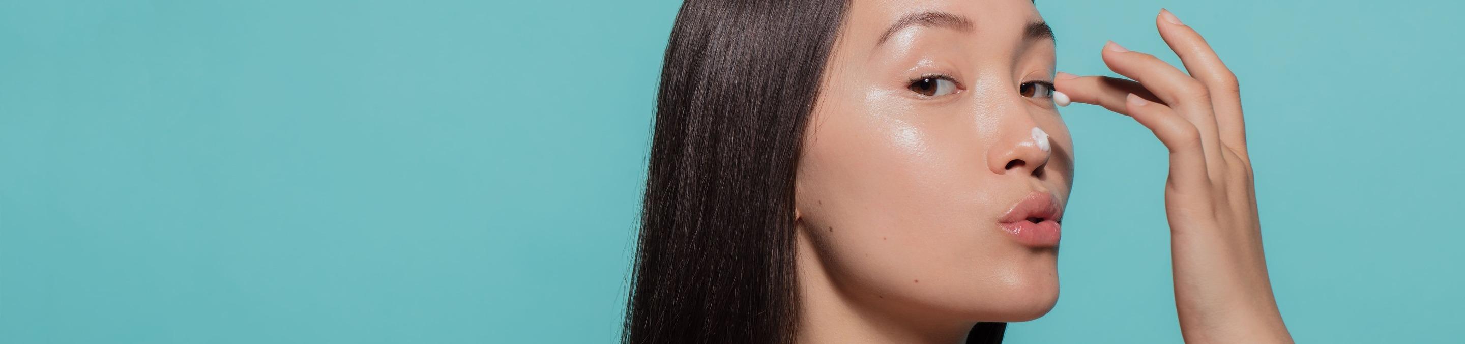 Femme s'appliquant des soins cosmétiques au format desktop 