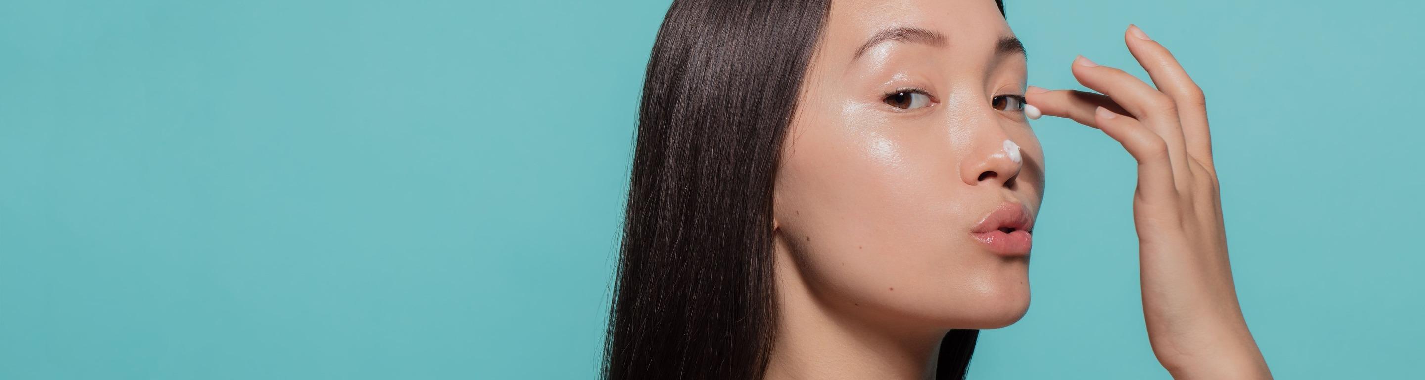 Femme s'appliquant des soins cosmétiques au format grand desktop 