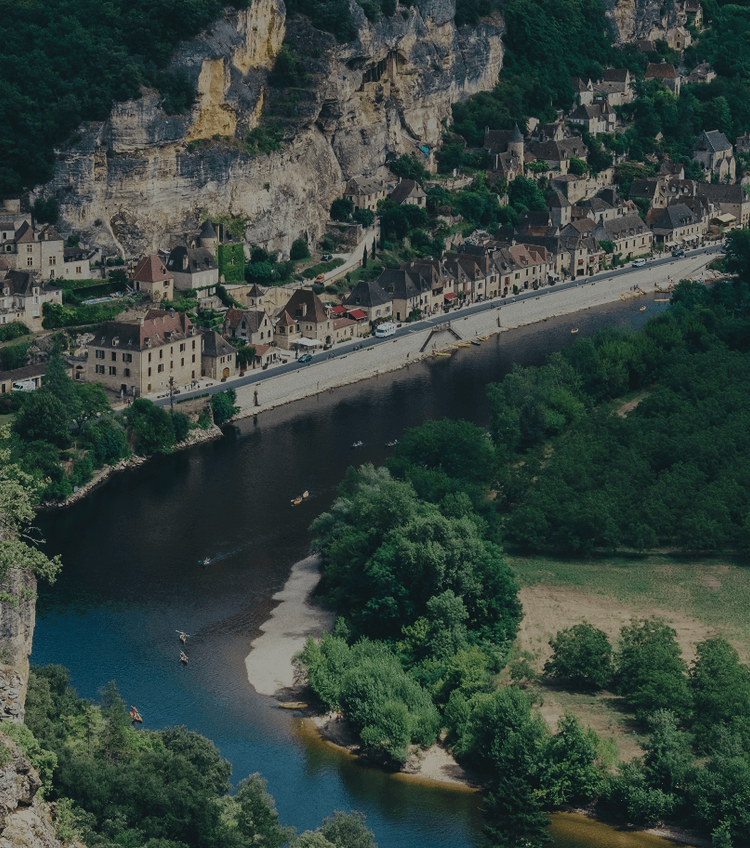 Vue d’un village en bord de rivière illustrant la publicité locale en télévision et en radio au 1er semestre 2024.