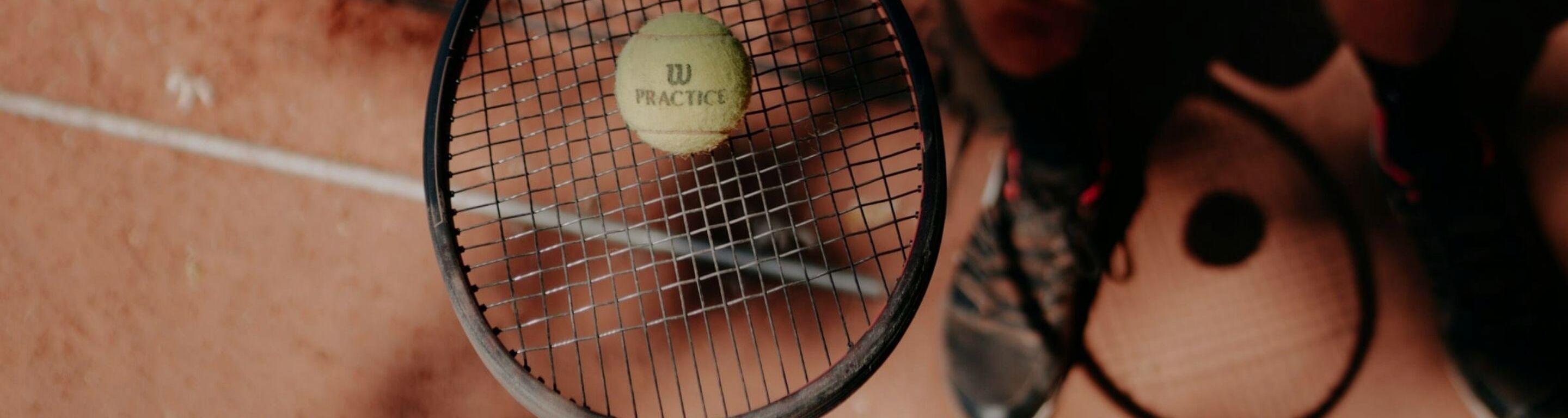 Raquette avec une balle de tennis sur terre battu