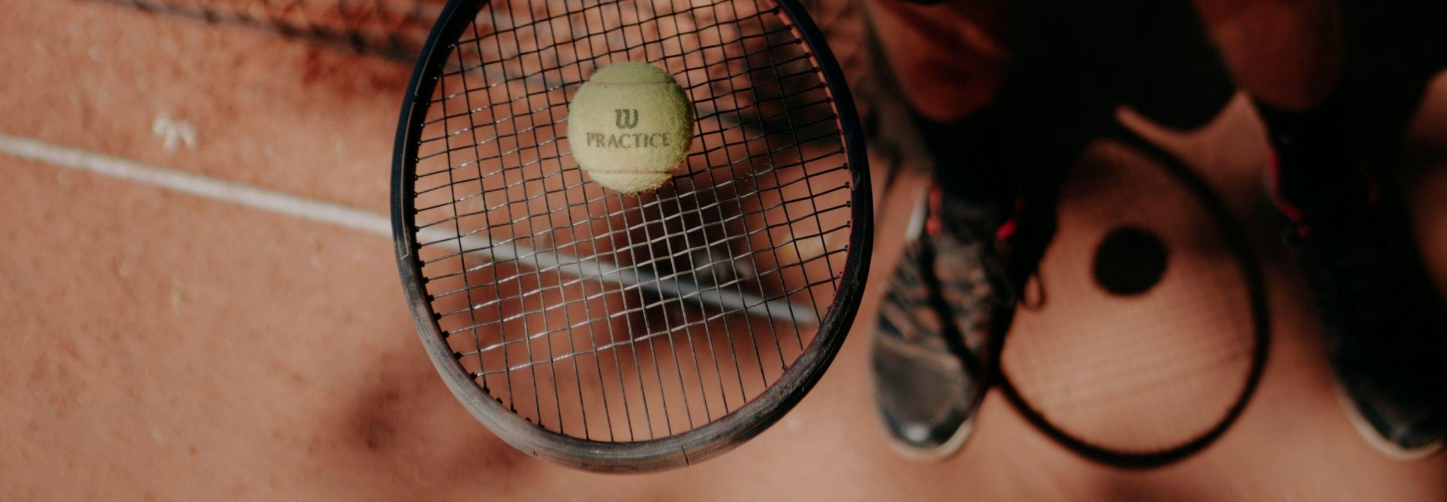 Raquette avec une balle de tennis sur terre battu